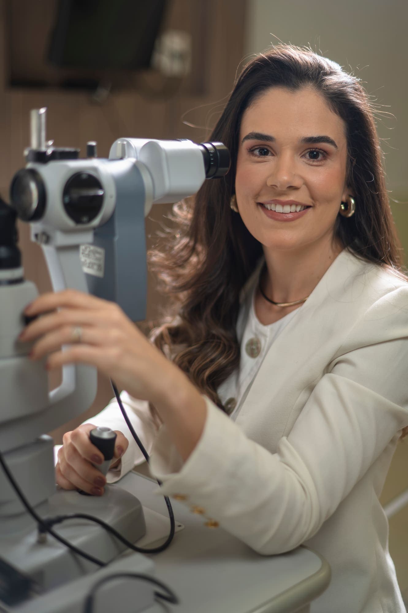 Dra. Mariana Lopes sorrindo ao lado da lâmpada de fenda