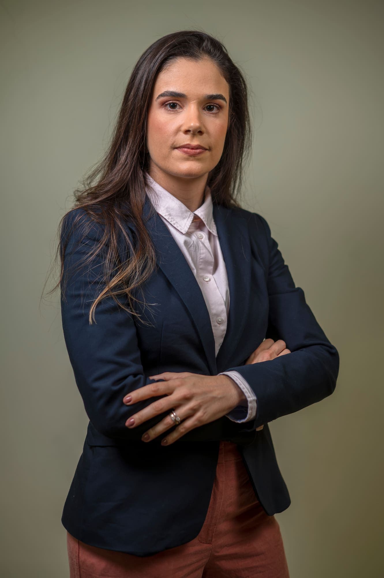 Dra. Mariana Lopes de blazer azul-marinho, de braços cruzados